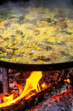 Geleneksel Valensiyalı paella pişirme süreci: İspanya 'da et suyu azaltmalı pirinç pişirme aşaması.