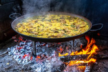 Geleneksel Valensiyalı paella pişirme süreci: İspanya 'da et suyu azaltmalı pirinç pişirme aşaması.