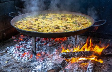 Geleneksel Valensiyalı paella pişirme süreci: İspanya 'da et suyu azaltmalı pirinç pişirme aşaması.