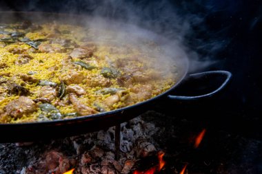 Geleneksel Valensiyalı paella pişirme süreci: İspanya 'da et suyu azaltmalı pirinç pişirme aşaması.