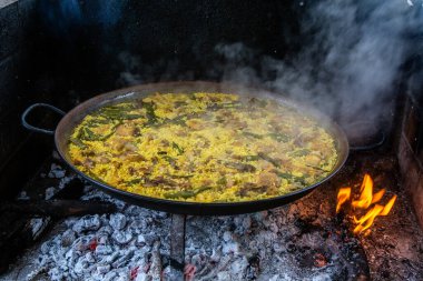 Geleneksel Valensiyalı paella: klasik kuru pirinç dokusunu ve Akdeniz sunumunu gösteren bitmiş yemek.
