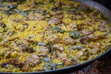 Geleneksel Valensiyalı paella: klasik kuru pirinç dokusunu ve Akdeniz sunumunu gösteren bitmiş yemek.
