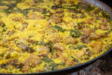 Geleneksel Valensiyalı paella: klasik kuru pirinç dokusunu ve Akdeniz sunumunu gösteren bitmiş yemek.
