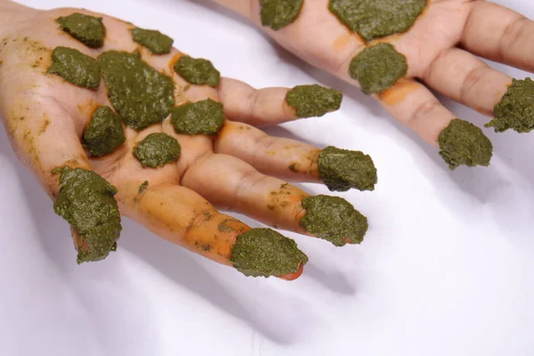 フレッシュメヒンディー語緑の葉 Lawsonia Inermis 白い背景に隔離された適用女性の手を貼り付ける — ストック写真