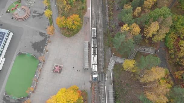 Von oben nach unten Straßenbahn Abfahrt Straßenbahnhaltestelle, Herbstlaubszenerie, Antenne — Stockvideo