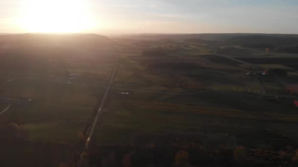 Lange rechte weg in weids groen landschap bij zonsondergang, antenne — Stockvideo
