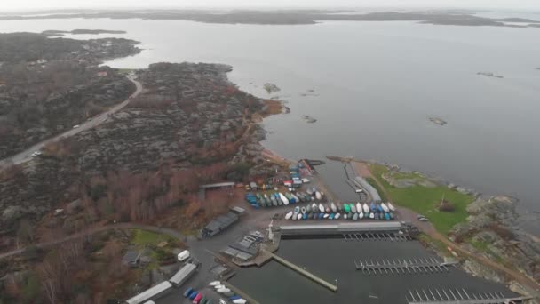 Rocky Coast με Winterized Boats στο Small Harbour, Aerial Backward — Αρχείο Βίντεο