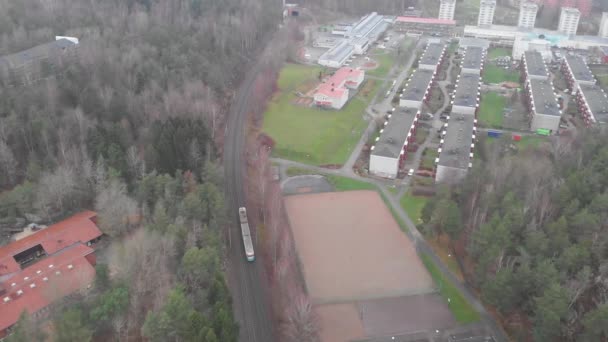 Einfache Straßenbahn durch die Vorstadt mit Wohnungen und Wald, Luftaufnahmen — Stockvideo