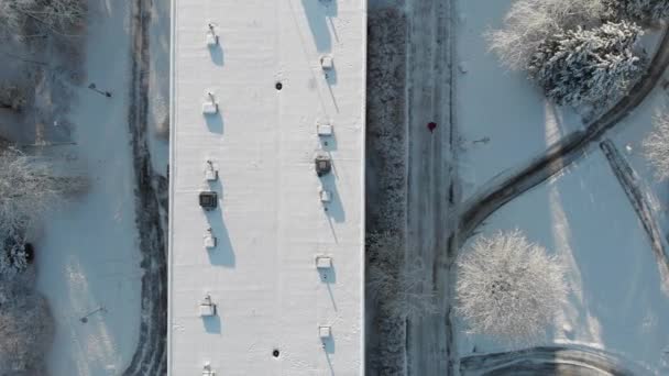 冬日空中俯瞰员与白雪覆盖的楼宇天台并肩行走 — 图库视频影像