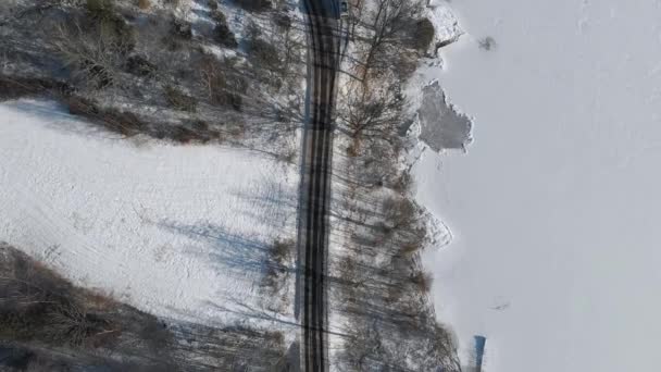 沿著海岸线、结冰湖和雪的道路，空中俯冲而下 — 图库视频影像