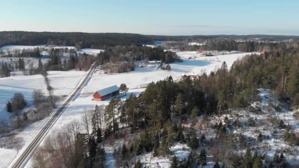 Traditionele schuur en landbouwgrond in Zweden tijdens de winter, in de lucht — Stockvideo