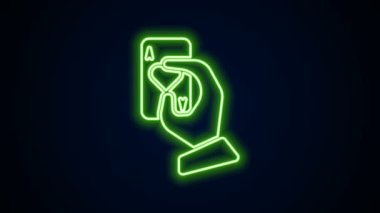 Parlayan neon çizgisi El 'in elinde siyah arkaplanda izole edilmiş iskambil simgesi var. Kumarhane oyun tasarımı. 4K Video hareketli grafik canlandırması