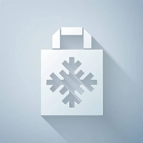 紙はグレーの背景に隔離された雪の結晶アイコンとクリスマス紙のショッピングバッグをカット 荷物のサインだ メリークリスマスとハッピーニューイヤー 紙のアートスタイル ベクトル — ストックベクタ