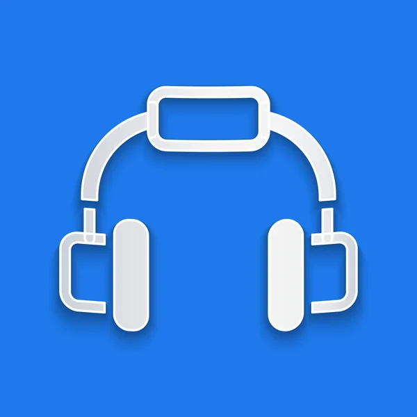 Papel corte Headphones ícone isolado no fundo azul. Fones de ouvido. Conceito para ouvir música, serviço, comunicação e operador. Estilo de arte de papel. Vetor —  Vetores de Stock