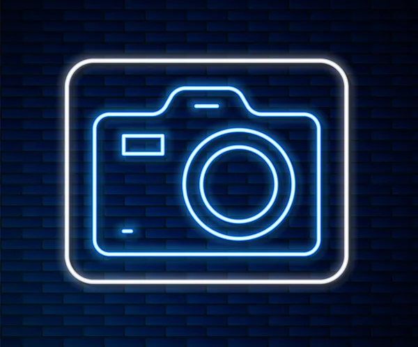 Gloeiende neon lijn Fotocamera icoon geïsoleerd op bakstenen muur achtergrond. Foto camera. Digitale fotografie. Vector — Stockvector