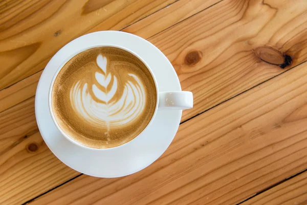 Hot milk art coffee on wooden table — Stock Photo, Image