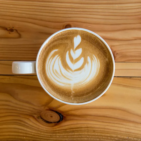 Café quente da arte do leite na mesa de madeira — Fotografia de Stock