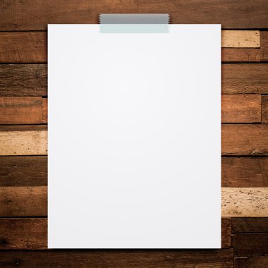 Boş beyaz kağıt levha sopa ahşap arka plan üzerinde.
