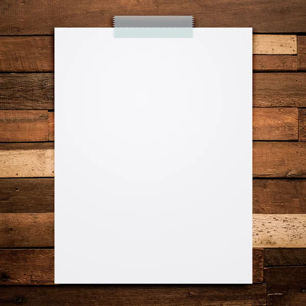 Boş beyaz kağıt levha sopa ahşap arka plan üzerinde.