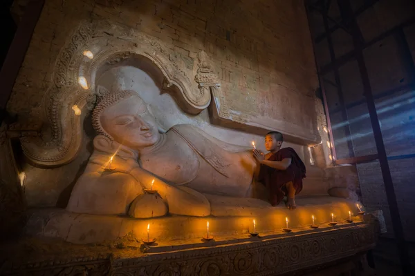 Kleiner Mönch, der die Kerze im alten Tempel verbrennt. bagan. Myanmar. — Stockfoto