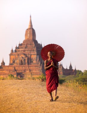 acemi monk ile kırmızı şemsiye Sulamani pagodadan önünde yürüyüş.