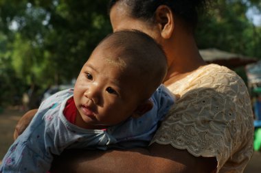 Baby of Burmese with thanaka on his face ,Thanaka is powder or cosmetic made from a tree