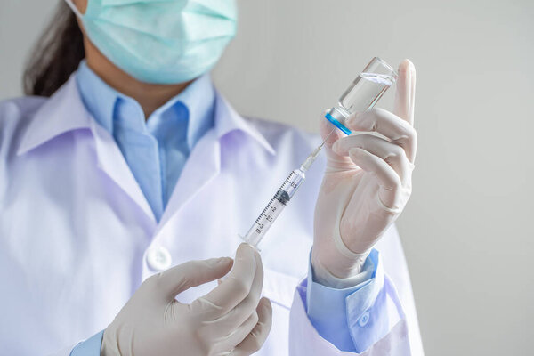 Врач или ученый, заполняющий шприц лекарствами в лаборатории, держит шприц с жидкими вакцинами. Вакцинация и иммунизация. close up.