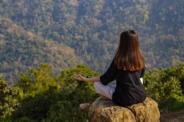 Dağlarda meditasyon yapan bir kadın, meditasyon, dinginlik, yaşam tarzı rahatlama, duygusal, doğa ile açık hava uyumu..