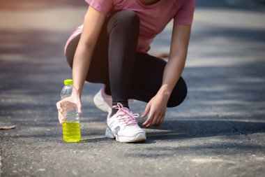 Kadın sporcu sporcuların ve elektrolitlerin yakın çekimi. Açık hava koşusu sonrası terleyen Asyalı kadın..