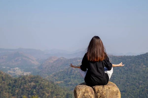 Woman meditating yoga at mountains, practices meditation, serenity, Lifestyle relaxation, Emotional, Outdoor harmony with nature.