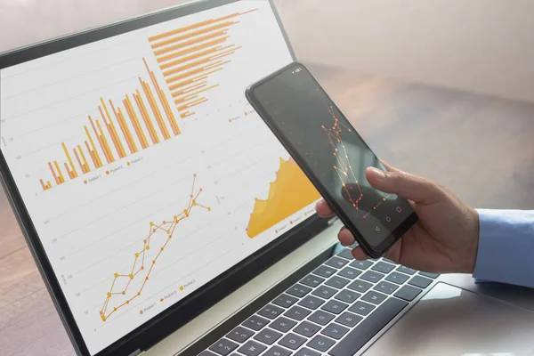 Cep telefonu ve bilgisayar laptopuyla çalışan bir iş kadını. İş bilgileri ve grafikleri. Piyasa analizi. Araştırma bilgileri. Finansal rapor analiz ediliyor. İş teknolojisi kavramı.