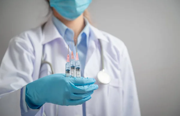 Doktor ya da bilim adamı elinde sıvı aşılayıcı olan bir şırınga tutuyor. Virüs covid-19 koronavirüse, aşıya ve aşılamaya karşı savaş. hastalıklar, tıbbi bakım, bilim, aşı destekleyici kavram.