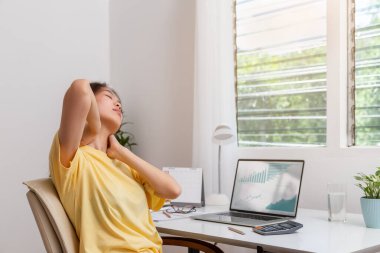Ofis sendromu konsepti. Bilgisayarda uzun süre çalıştıktan sonra boynuna masaj yapan kadın boynundaki ağrıyı hissediyor. Boyun yorgunluğu, kas ağrısı veya dizüstü bilgisayar kullanırken yanlış duruş..