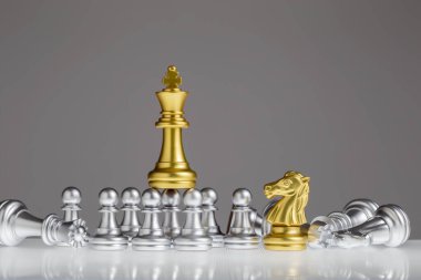 Altın satranç kralı gümüş piyonun üzerinde duruyordu. King oyunu, başarıyı, stratejiyi, zaferi, şah mat 'ı, konsept liderliği ve iş stratejisi planını kazanır..