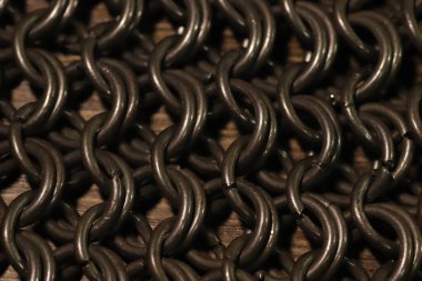 Zincir zırh kumaş, tahta yüzeyde çelik halkalar.