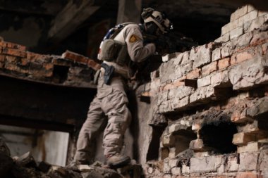 Amerikan askeri üniformalı bir adam yıkık dökük bir binada duruyor bir yığın oda, hava yumuşaklığı spor oyunu