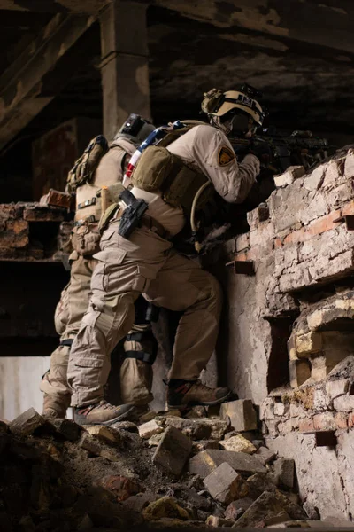 アメリカ軍の制服を着た2人の男が老朽化した建物の石の上に立つエアソフトスポーツゲーム軍のシミュレーション — ストック写真