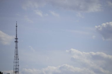 Bulutlu mavi gökyüzünün arka planında demir kule