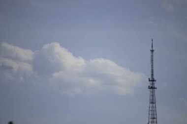 Bulutlu mavi gökyüzünün arka planında demir kule