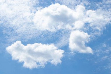 Beyaz pofuduk bulutlar güneşli bir günde Mavi gökyüzünde bir yaz gününde