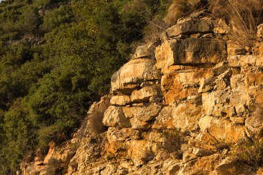 Vlor, Arnavutluk 17 Ağustos 2025: Güneşli kayalık uçurumların sıcak altın tonlarında yakın görüntüsü.