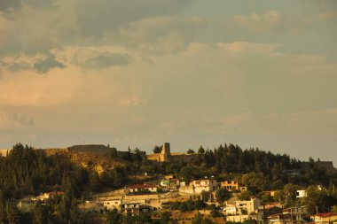 Arnavutluk 'un Vlora kenti yakınlarındaki barışçıl bir yamaç köyü, 17 Ağustos 2025' te yoğun yeşil ormanlar ve dağ sırtlarıyla çevrili uzun bir minaresi olan beyaz bir camiye ev sahipliği yapıyor..