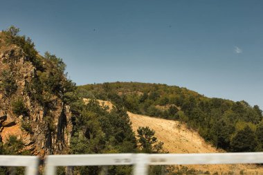 Engebeli yamaçları olan manzaralı bir dağ manzarası, dağınık bitki örtüsü Ağustos 2025