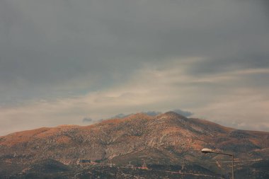 Engebeli yamaçları olan manzaralı bir dağ manzarası, dağınık bitki örtüsü Ağustos 2025