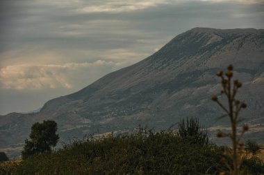 Engebeli yamaçları olan manzaralı bir dağ manzarası, dağınık bitki örtüsü Ağustos 2025
