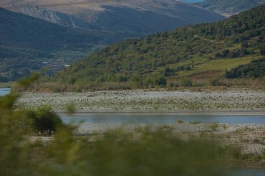 Ağustos 2025 'te yoldan görünen kıvrımlı bir nehir ile dağ vadisi manzarası