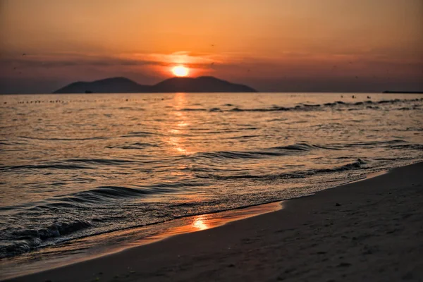 Vlora, Arnavutluk 21 Ağustos 2025. Adriyatik Denizi 'nin üzerinde sakin bir günbatımı. Sıcak altın ışık, yumuşak dalgalar ve uzak dağ siluetleri arasında yansıyor..