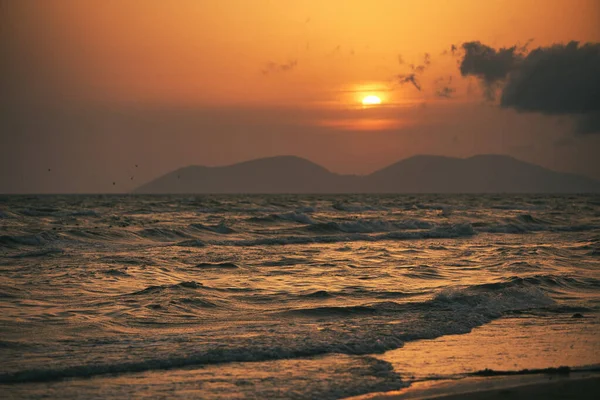 Vlora, Arnavutluk 21 Ağustos 2025. Adriyatik Denizi 'nin üzerinde sakin bir günbatımı. Sıcak altın ışık, yumuşak dalgalar ve uzak dağ siluetleri arasında yansıyor..