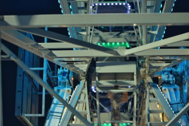 Arnavutluk 'un Vlora kenti 21 Ağustos 2025: Vlora kıyısındaki eğlence parkında aileleri, turistleri ve ziyaretçileri çeken parlak bir dönme dolap ve parlak bir atlıkarınca yer alıyor..