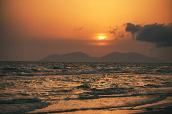 Vlora, Arnavutluk 21 Ağustos 2025. Adriyatik Denizi 'nin üzerinde sakin bir günbatımı. Sıcak altın ışık, yumuşak dalgalar ve uzak dağ siluetleri arasında yansıyor..